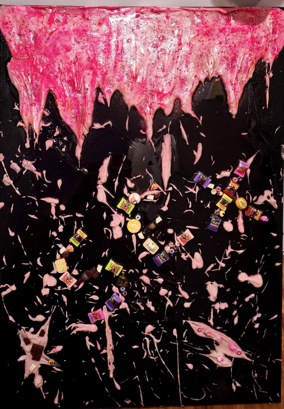 Dunkle Leinwand mit rosa Zuckerguss und verstreuten Süßigkeiten